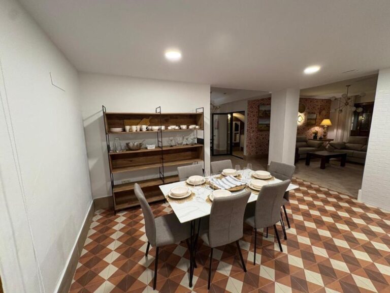 Una mesa de comedor con cuatro sillas, en un espacio interior de un alojamiento en Jaén