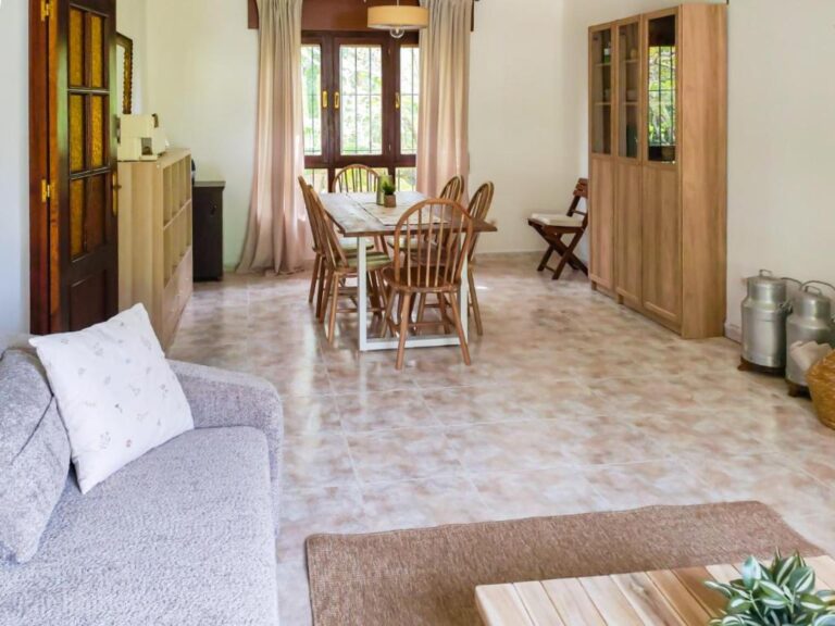 Una sala de estar con un sofá, una mesa de centro y una ventana con cortinas