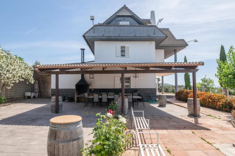 La terraza de un alojamiento en Montoro, con una mesa de comedor y sillas, y un barbacoa en el fondo