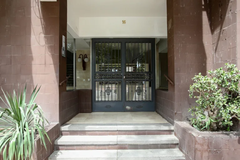 La entrada principal de un alojamiento en Sevilla, con una puerta de hierro forjado y un número de entrada en la parte