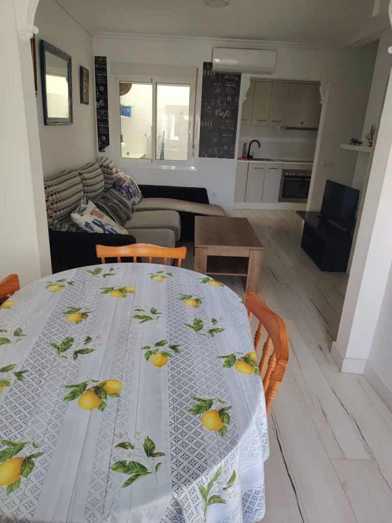 La cocina de un apartamento en Alicante, con un sofá y una mesa de comedor en el fondo