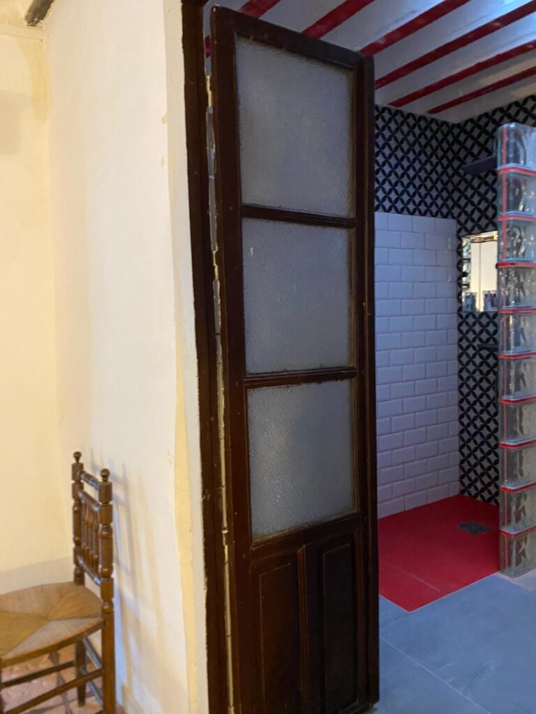 Una puerta de madera con vidrios en una casa de alquiler vacacional en Ciudad Real