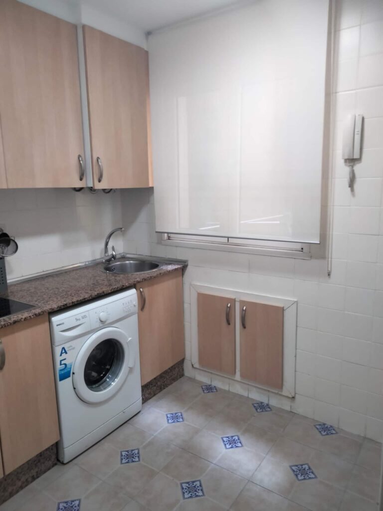 La cocina de este alojamiento en Oviedo cuenta con un lavavajillas blanco y un fregadero de granito
