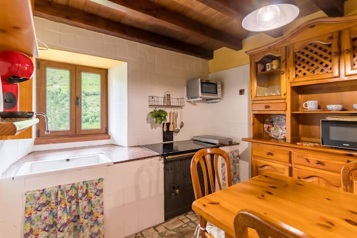 Una cocina con un fregadero y una mesa de madera