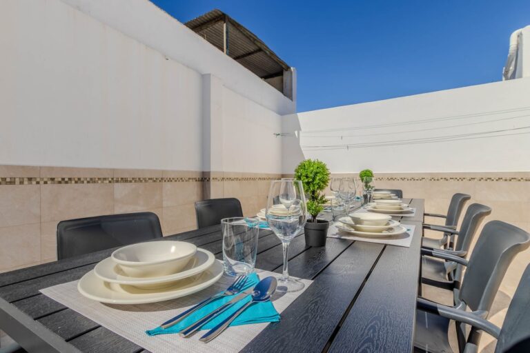 Una mesa de madera con una vista a la terraza de un alojamiento en Málaga, con una vista a la terraza