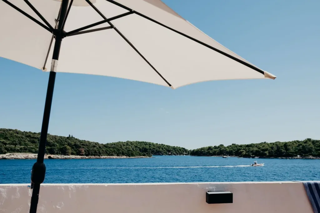 Terraza con sombrilla frente al mar; comisiones de Airbnb y Booking comparadas para propietarios