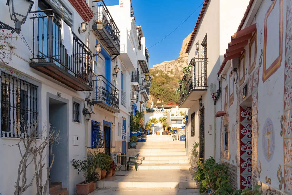 Calle encalada del barrio de Santa Cruz, entorno para publicar vivienda vacacional en Alicante