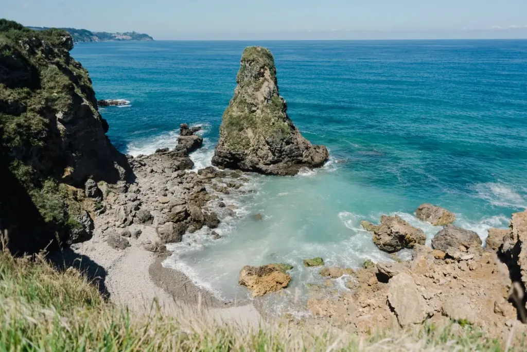 Cala rocosa de Gijón; viviendas que tramitan el registro turístico en Asturias