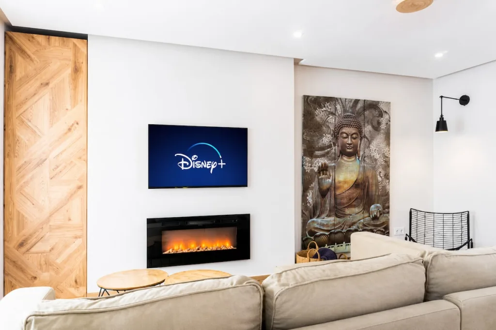 Un salón de un alojamiento en Málaga, con un televisor de pantalla plana montado en la pared, un fuego eléctrico