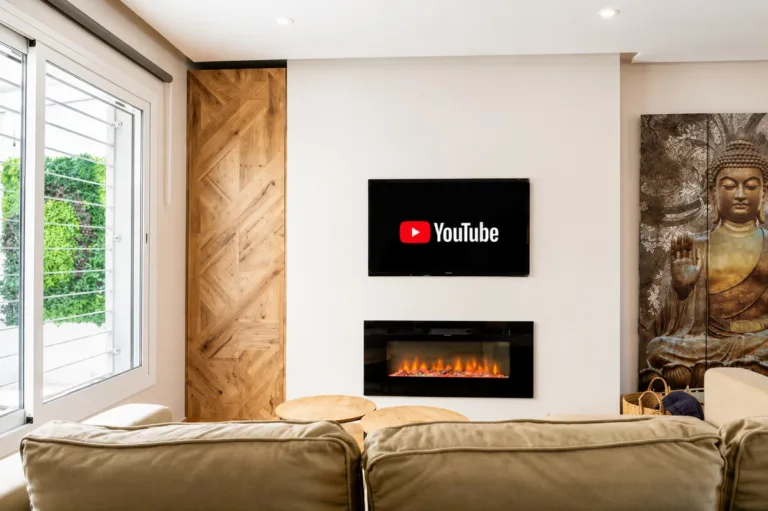 Una sala de estar con un televisor de pantalla plana y un pequeño fuego eléctrico en la pared
