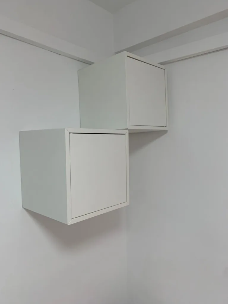 Un cuarto blanco con dos cajones blancos en la pared