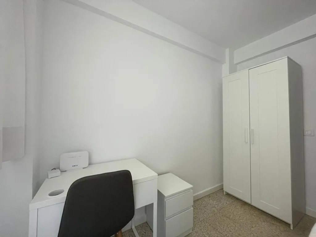 Una habitación con un escritorio y una estantería