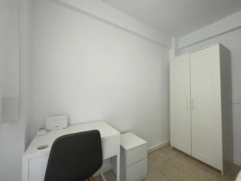 Una habitación con un escritorio y una estantería