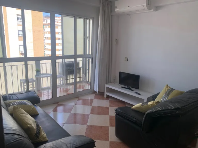 Un salón con una televisión y un sofá