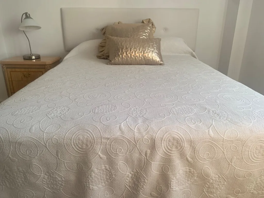 Una habitación con una cama y una mesita de noche