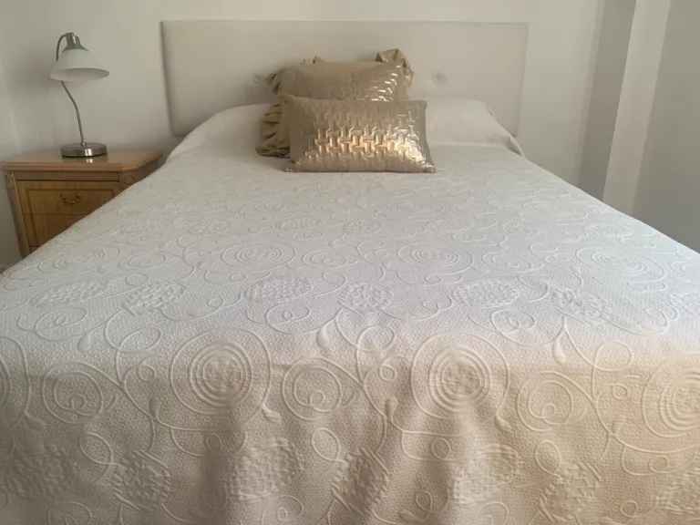 Una habitación con una cama y una mesita de noche