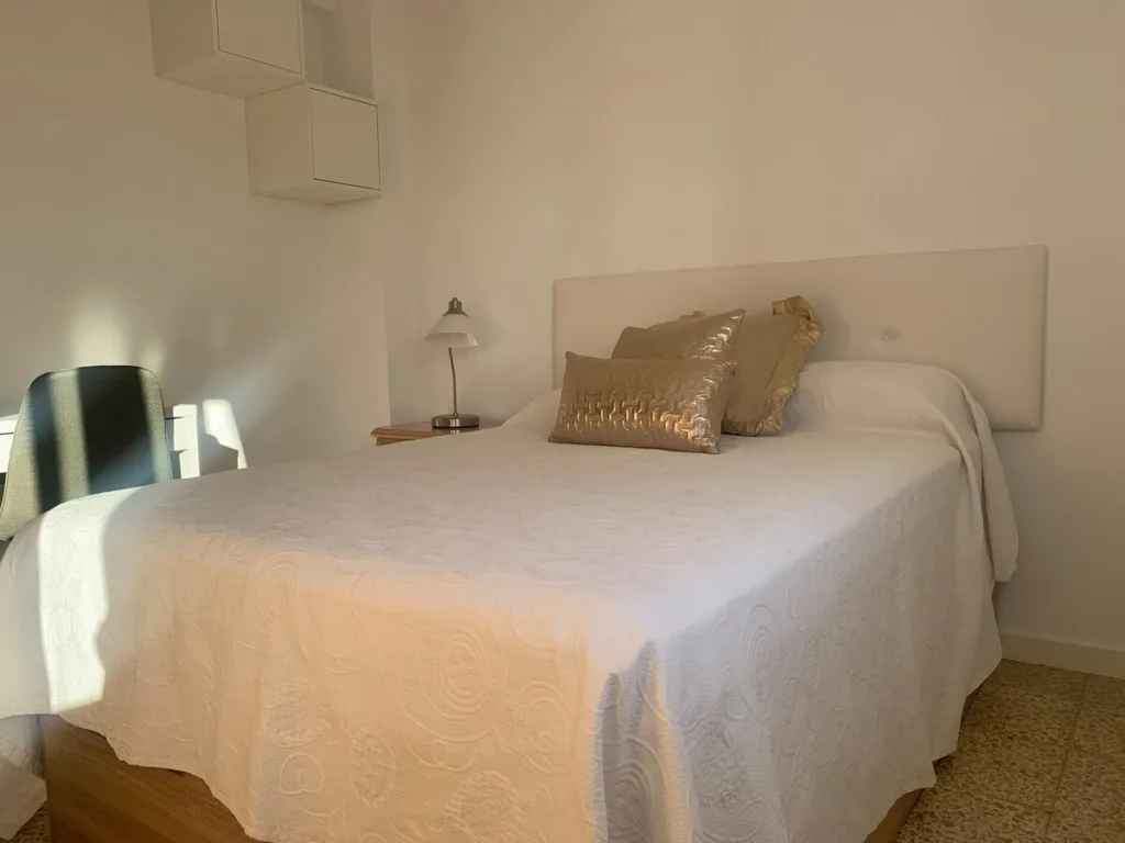 Una habitación con una cama y una lámpara