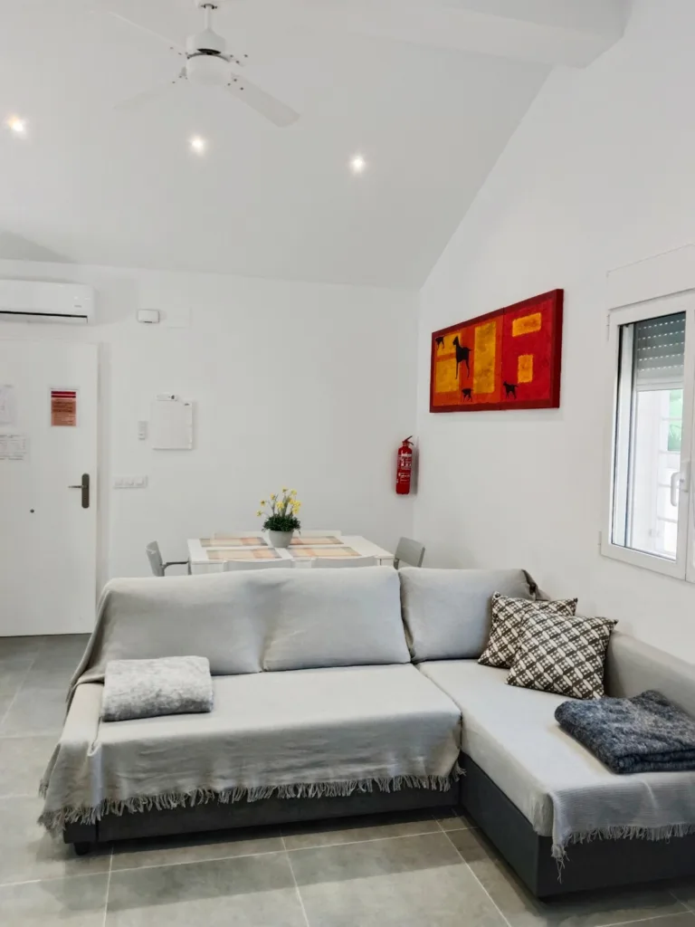 Un salón con un sofá y una mesa
