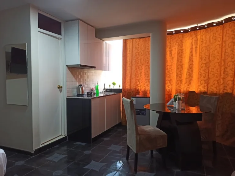 Una cocina con un pequeño comedor y una mesa redonda con dos sillas