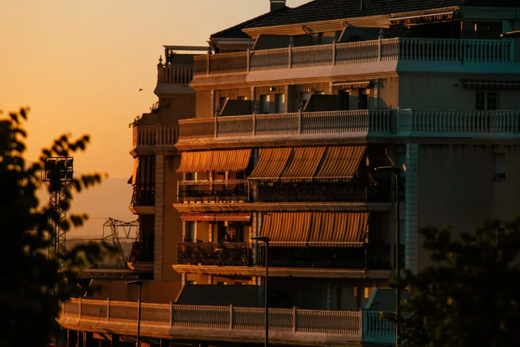 Edificio de apartamentos con terrazas al atardecer, afectados por la nueva comisión de Airbnb